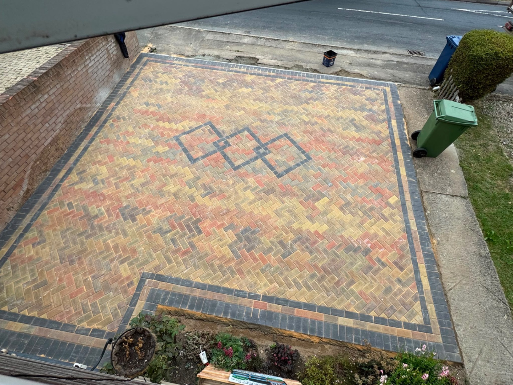 Overhead view of a completed autumn-blend herringbone block driveway in Gloucester